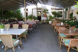 An outdoor dining area with wicker furniture and potted plants. - Millrather Brauhaus (Erkrath)