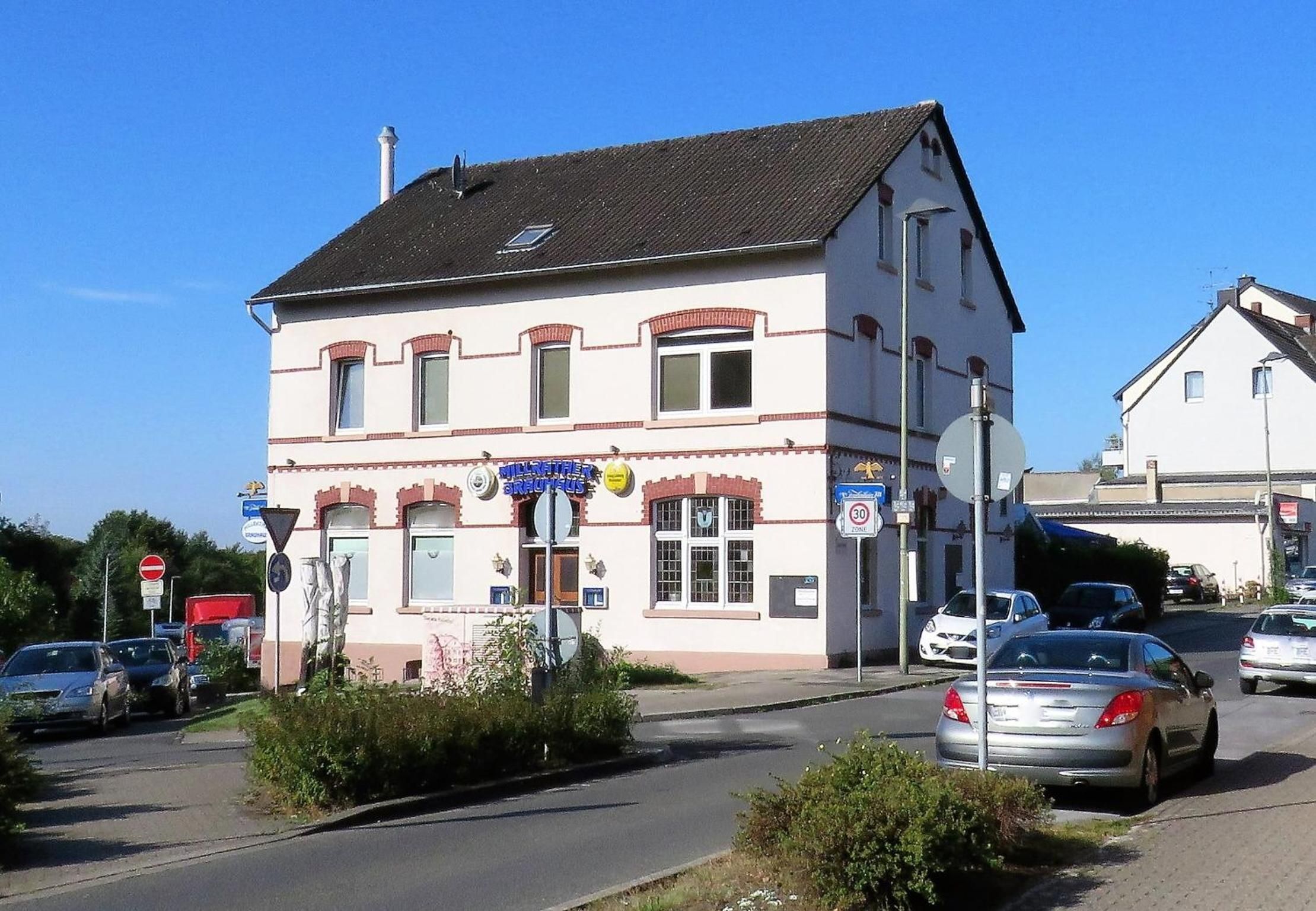 Un bâtiment à deux étages, sur lequel on peut voir une enseigne indiquant qu’il s’agit d’un restaurant. Des voitures sont garées devant, et un panneau « accès interdit » est visible.