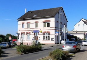 A two-story building with a sign indicating a restaurant. There are cars parked in front, and a no entry sign is visible. - Millrather Brauhaus (Erkrath)