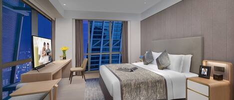 A modern hotel room with a large bed, a TV, a desk, and a view of the city.