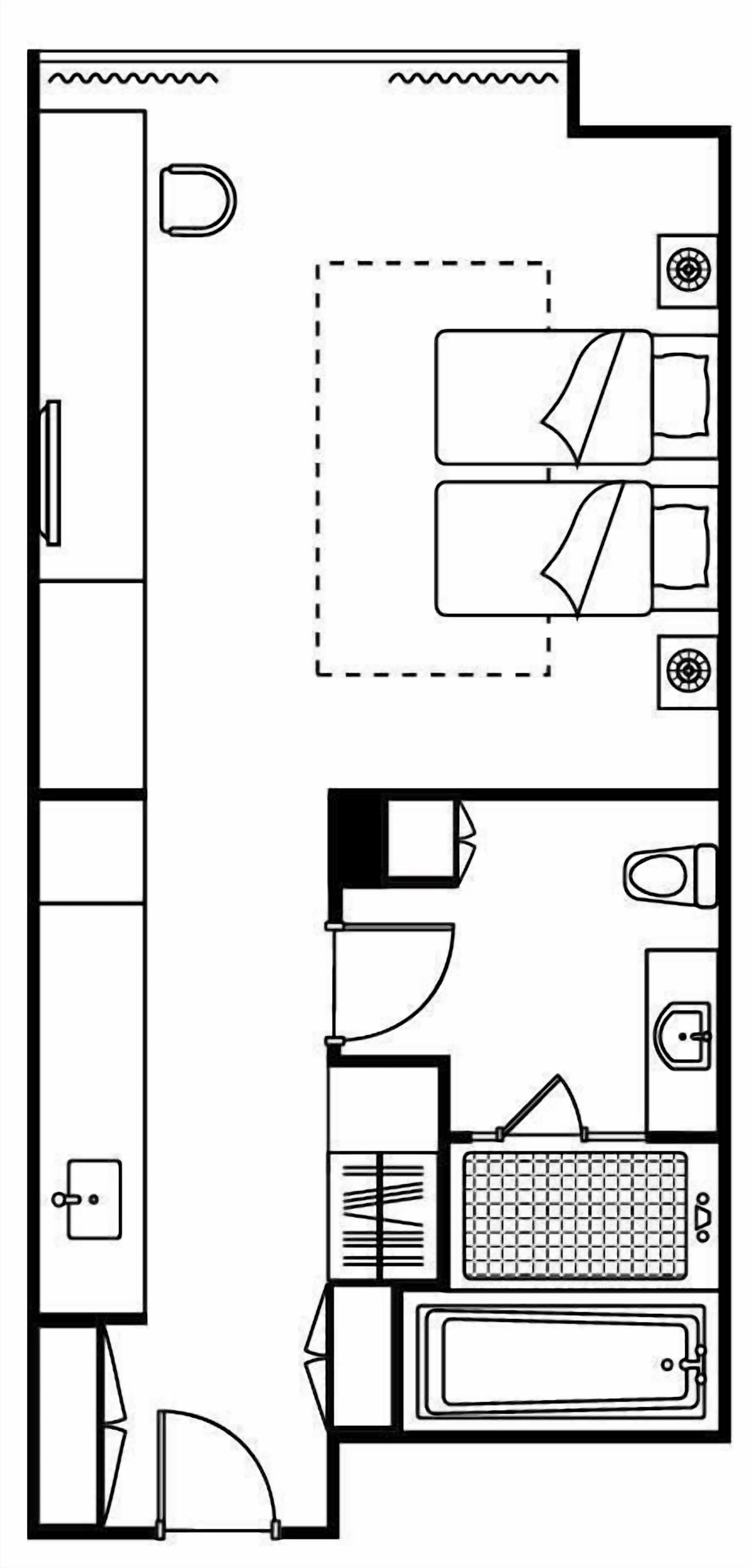 En planritning över ett hotellrum med en säng, ett skrivbord, ett badrum och ett litet kök.