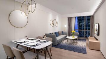 A modern living room with a dining area, a sofa, and a coffee table.