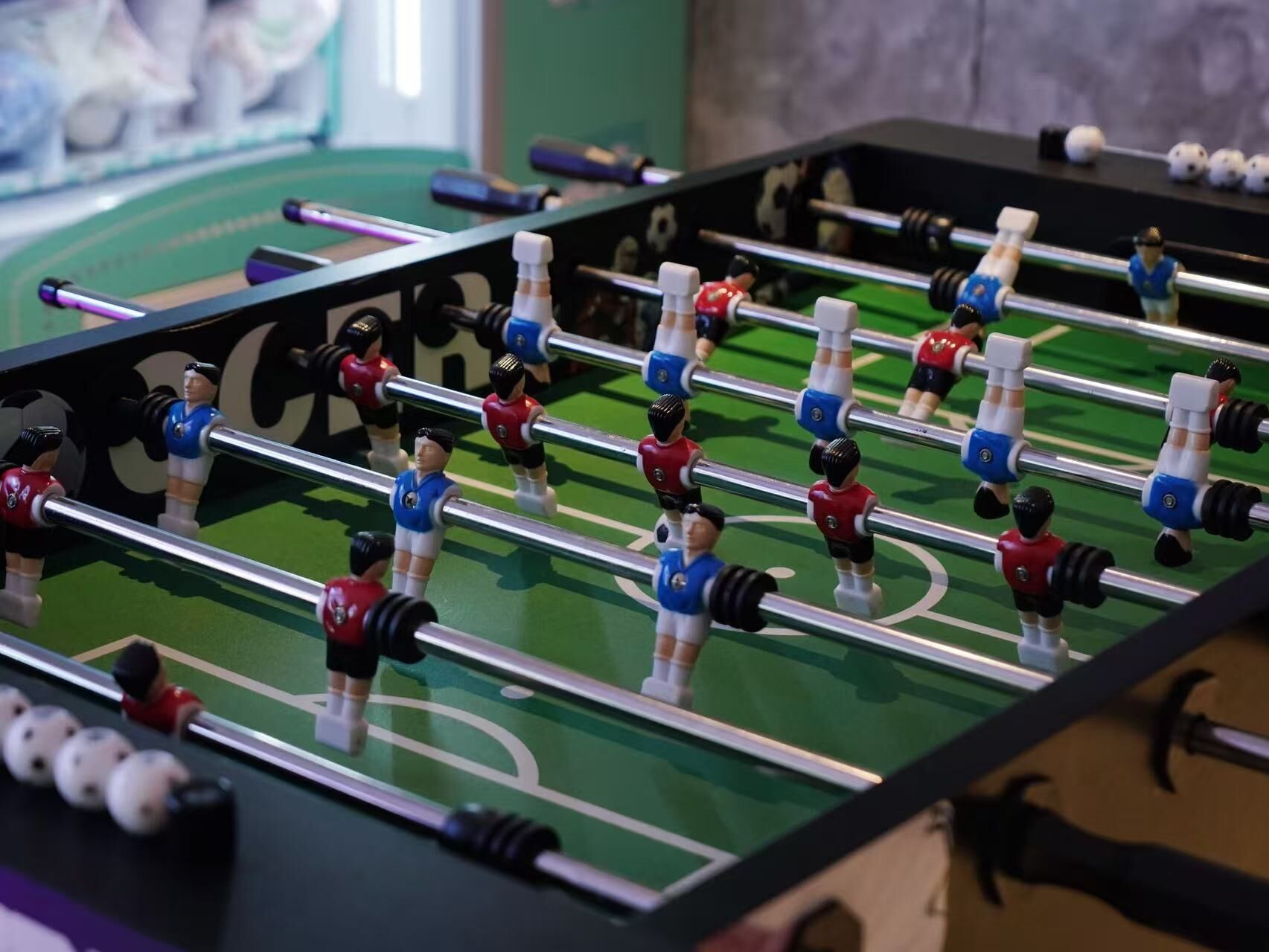 A foosball table with players in red and blue uniforms.