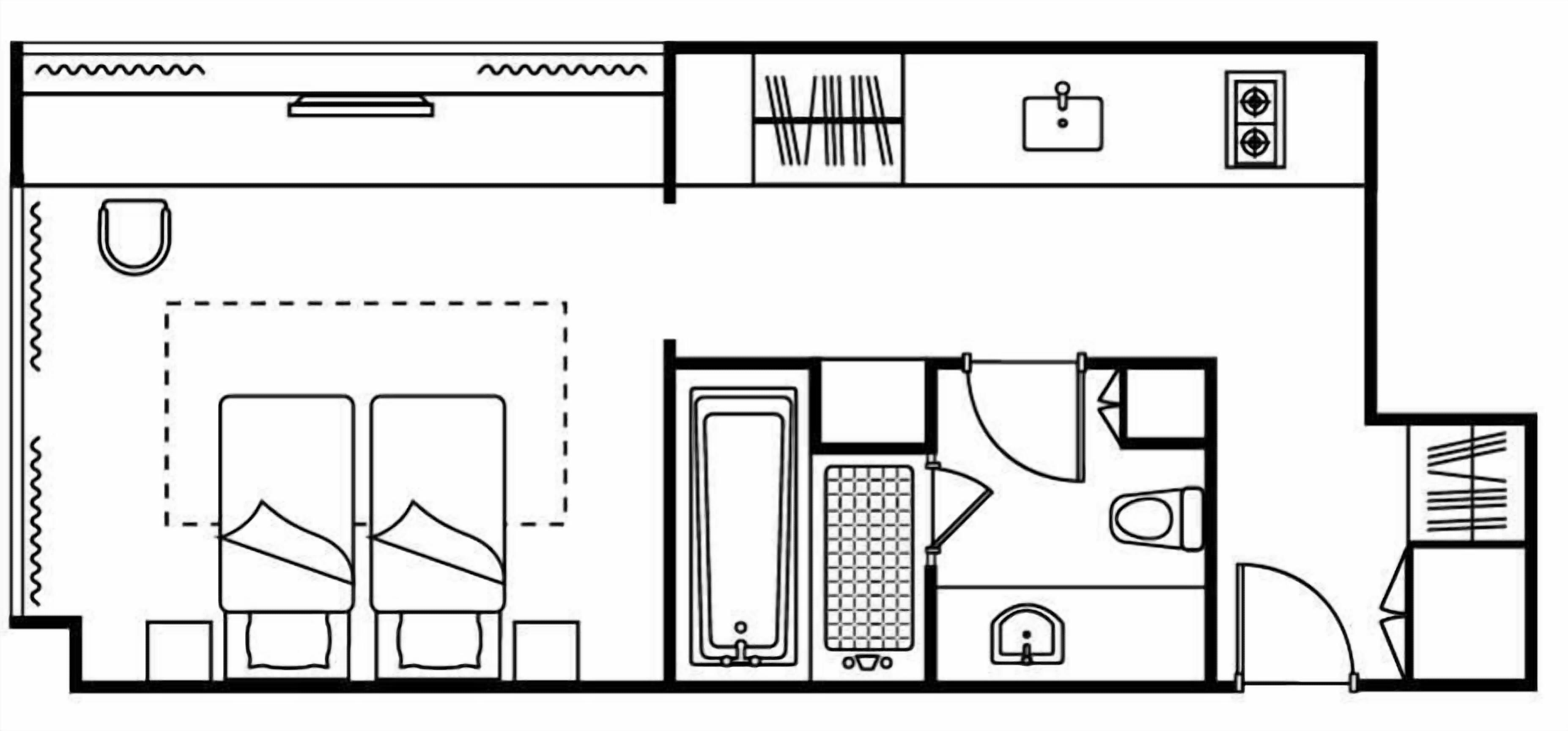A floor plan of a hotel room with a bed, a bathroom, a kitchenette, and a small seating area.