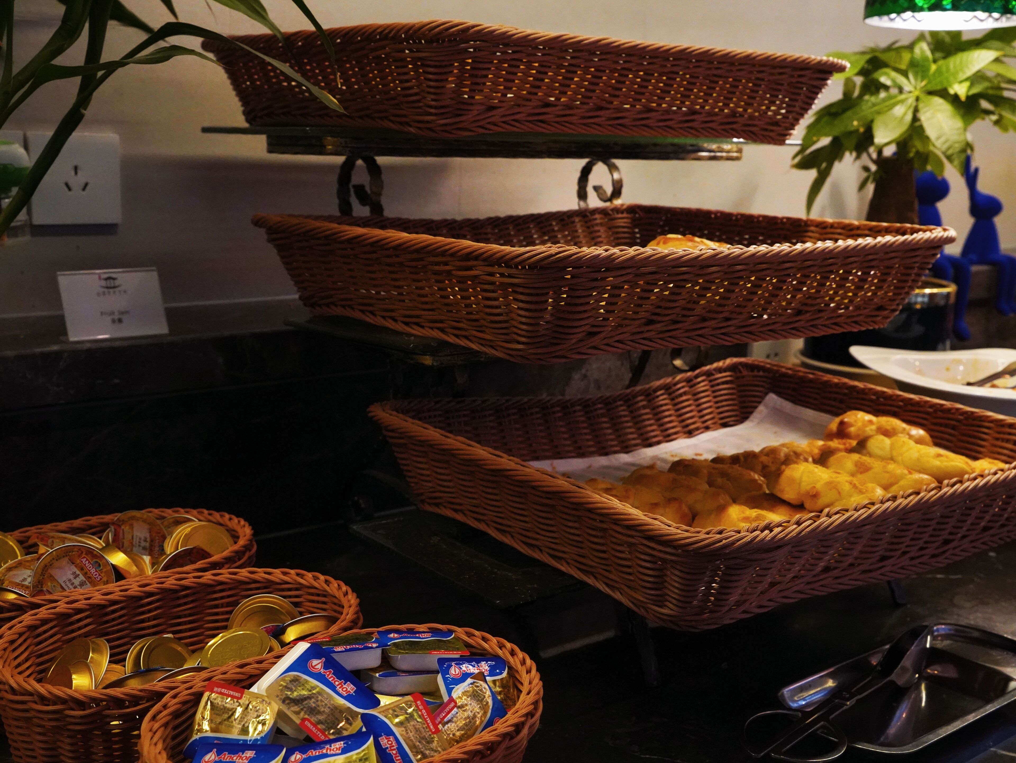 A buffet setup with wicker baskets containing food items and condiments.