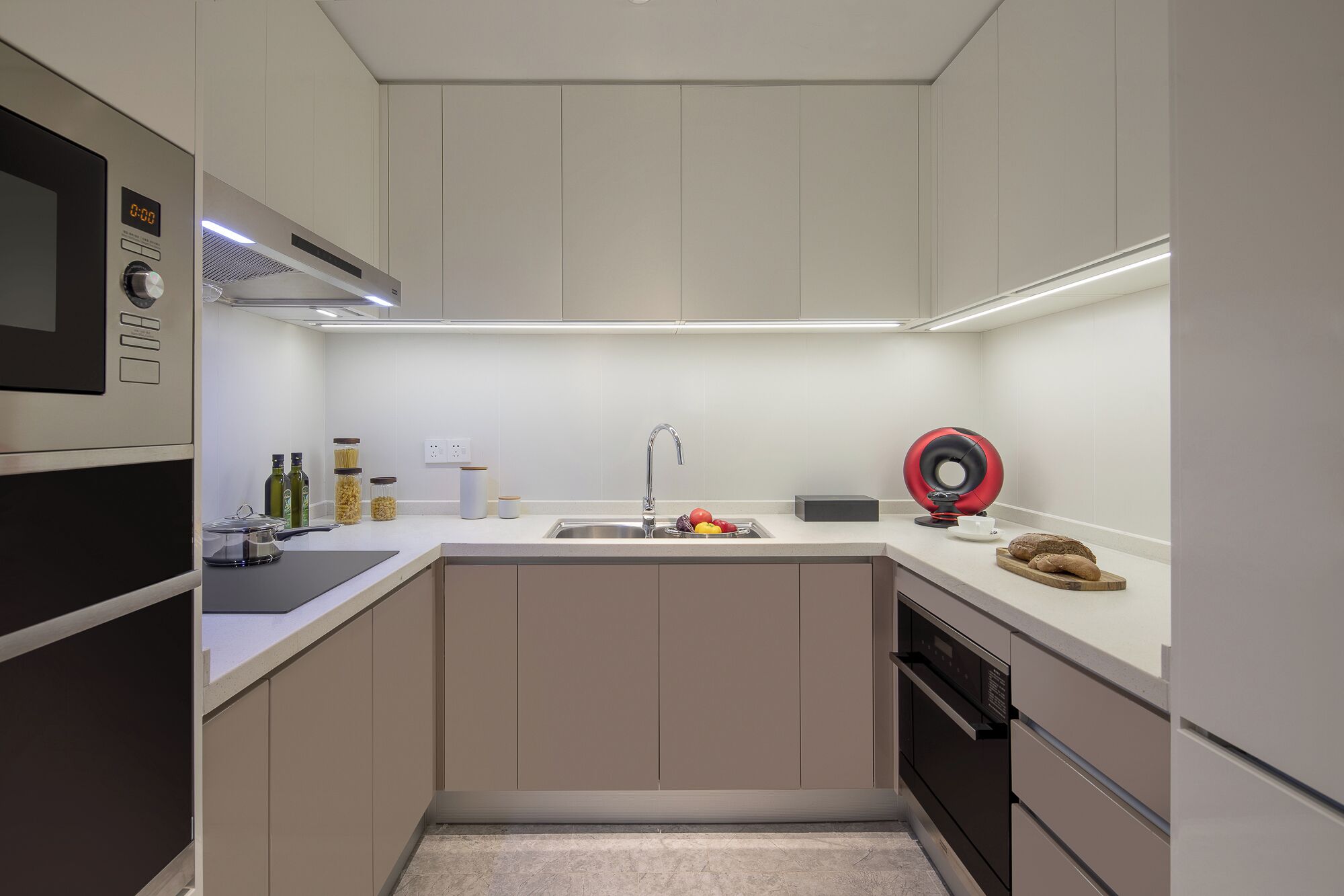 A compact kitchen with a built-in oven, a sink, and a dishwasher.