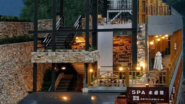 A multi-level spa with stone walls, wooden furniture, and a covered outdoor seating area. - Ming Lu Holiday Hotel (Ren'ai)