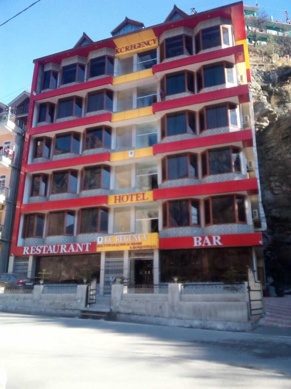 A multi-story building with signs for a hotel, restaurant, and bar.