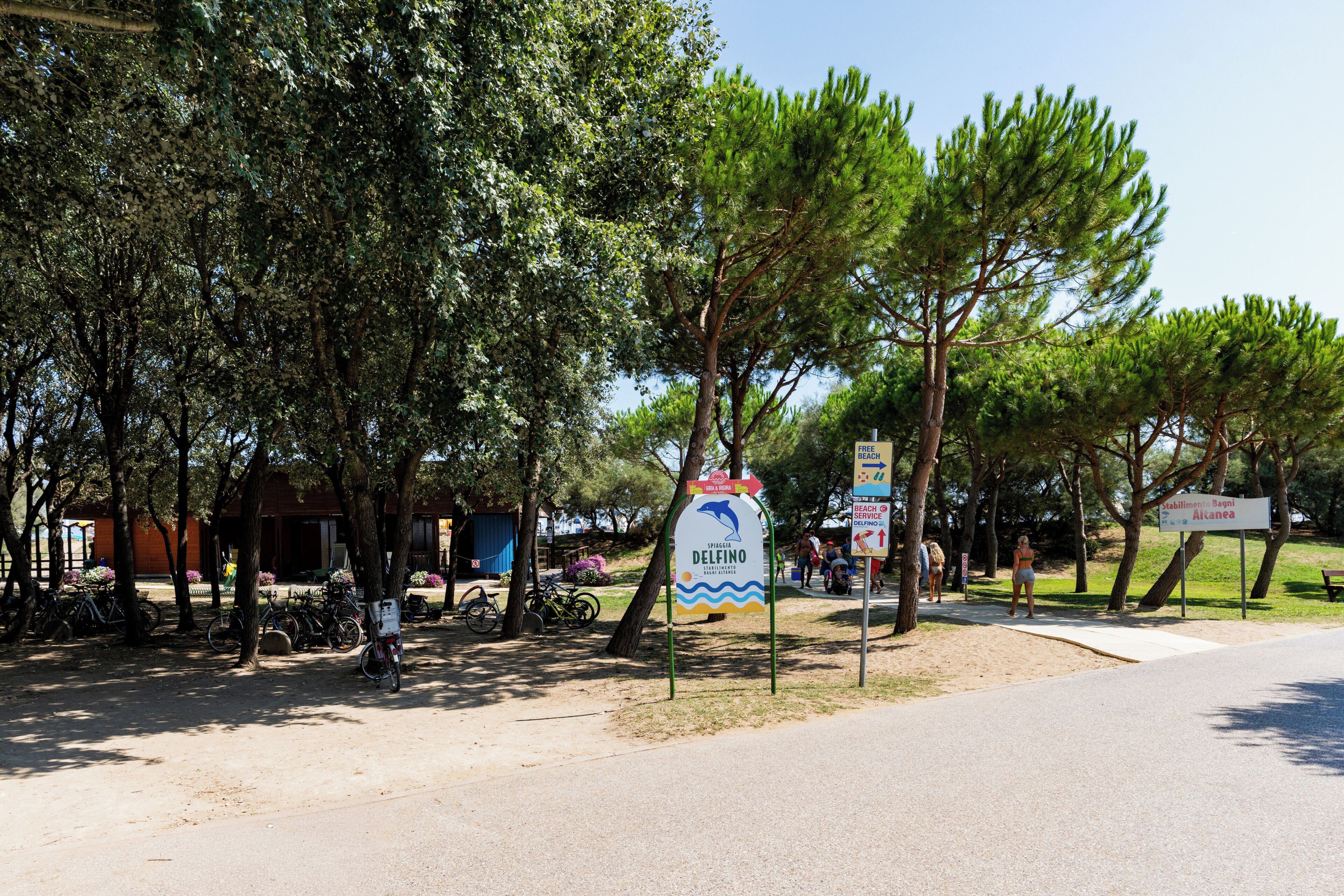 A beachside area with a sign indicating a free beach and a lifeguard station.