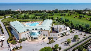 A modern hotel with a swimming pool, a landscaped garden, and a view of the sea. - Hotel Maregolf (Caorle)