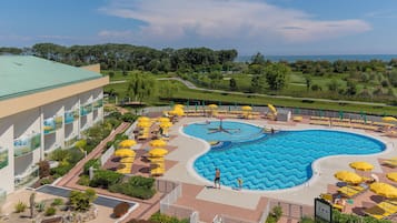 Una piscina al aire libre de temporada, sombrillas