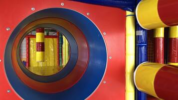 A circular play area with a blue and red exterior, surrounded by yellow and red padded walls.