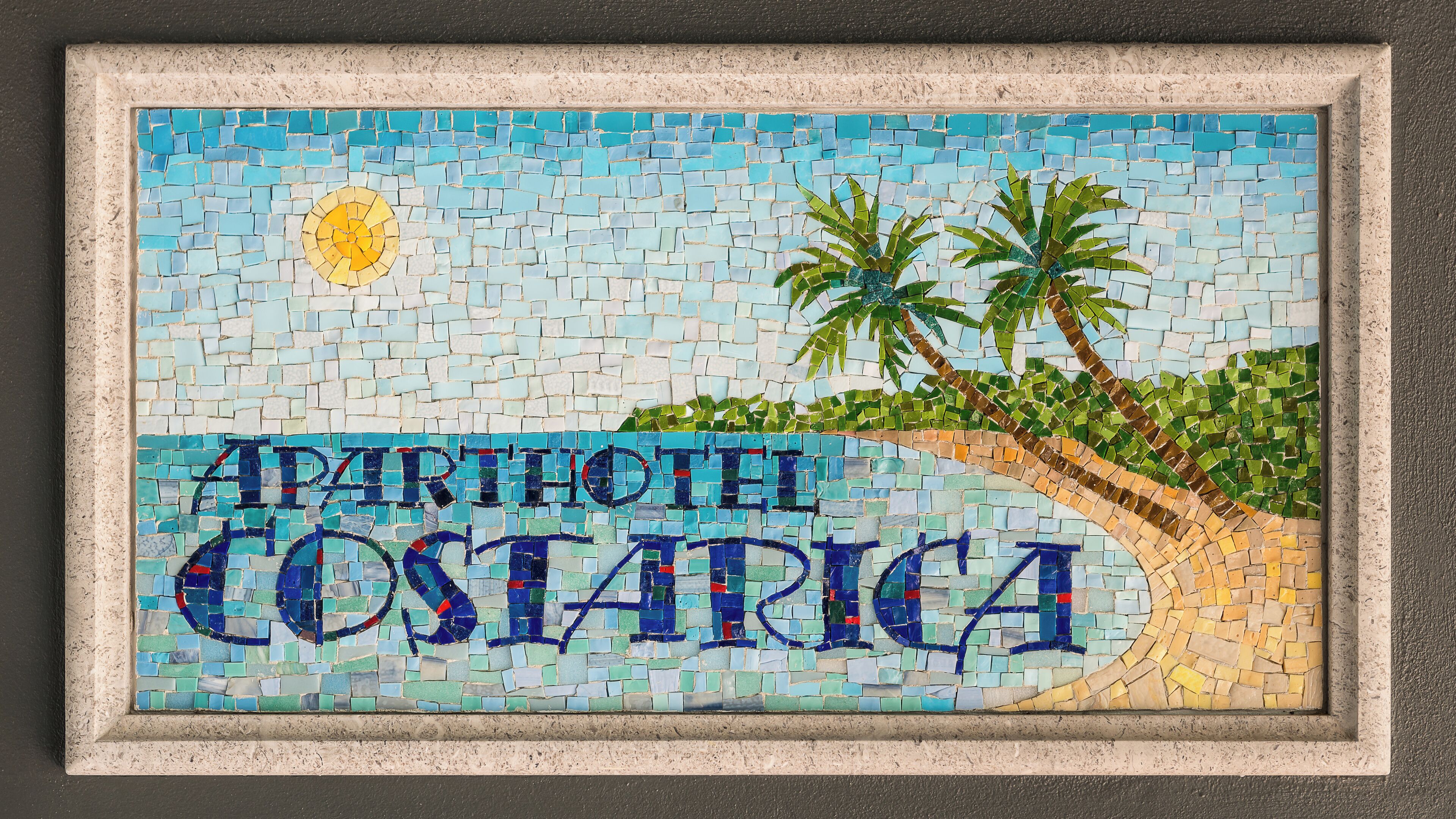 Une enseigne en mosaïque pour l’hôtel-résidence Costa Rica, représentant des palmiers et une scène de plage.