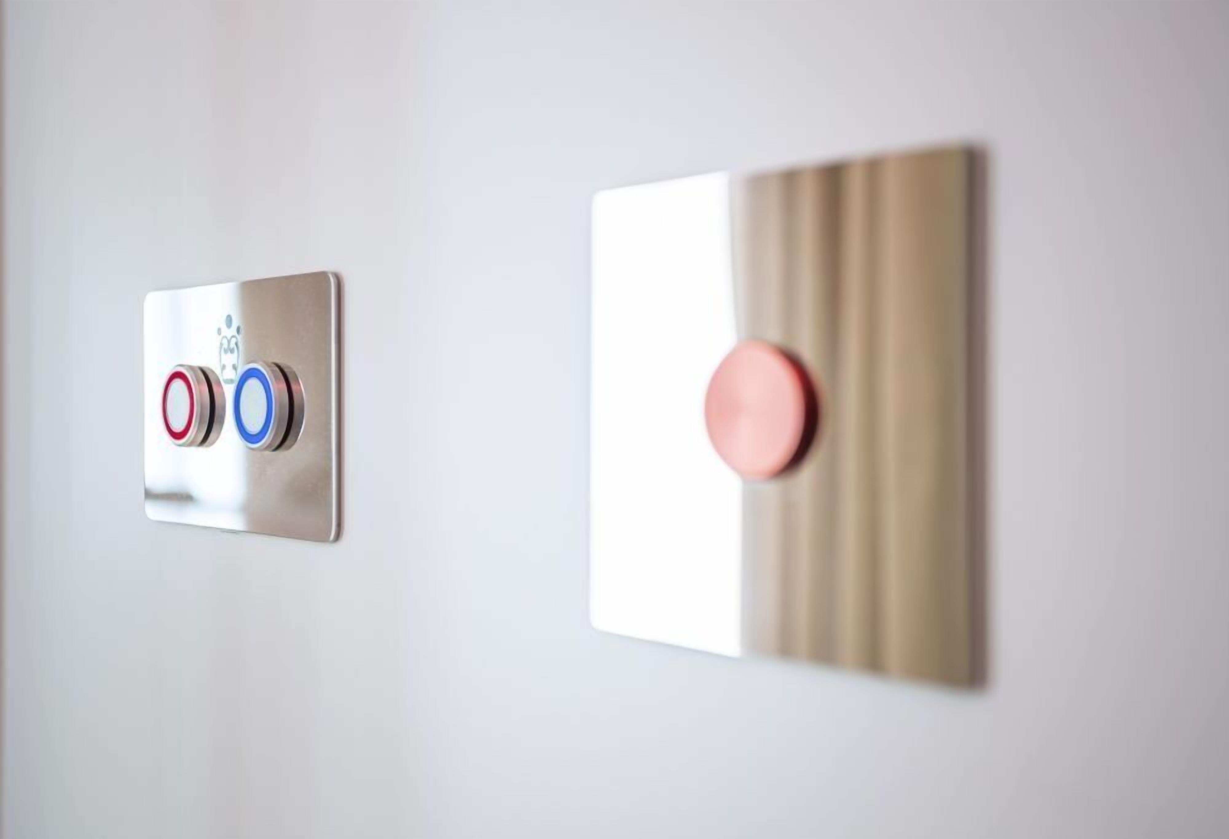 Un panel de control montado en la pared con tres botones y uno solo.