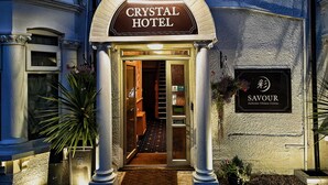The Crystal Hotel entrance with a sign for Savoir Authentic Chinese Cuisine. - Crystal Hotel (Cambridge)