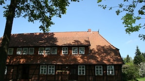 Un bâtiment traditionnel à deux étages, doté d’un toit en tuiles et de nombreuses fenêtres.