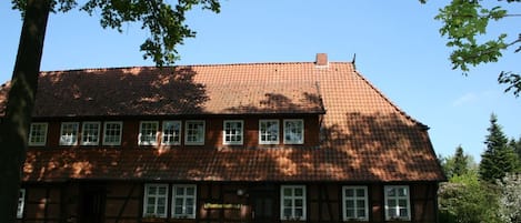 A traditional two-story building with a tiled roof and multiple windows.