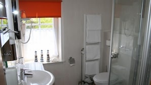 Une salle de bain avec un lavabo, des toilettes et une douche.