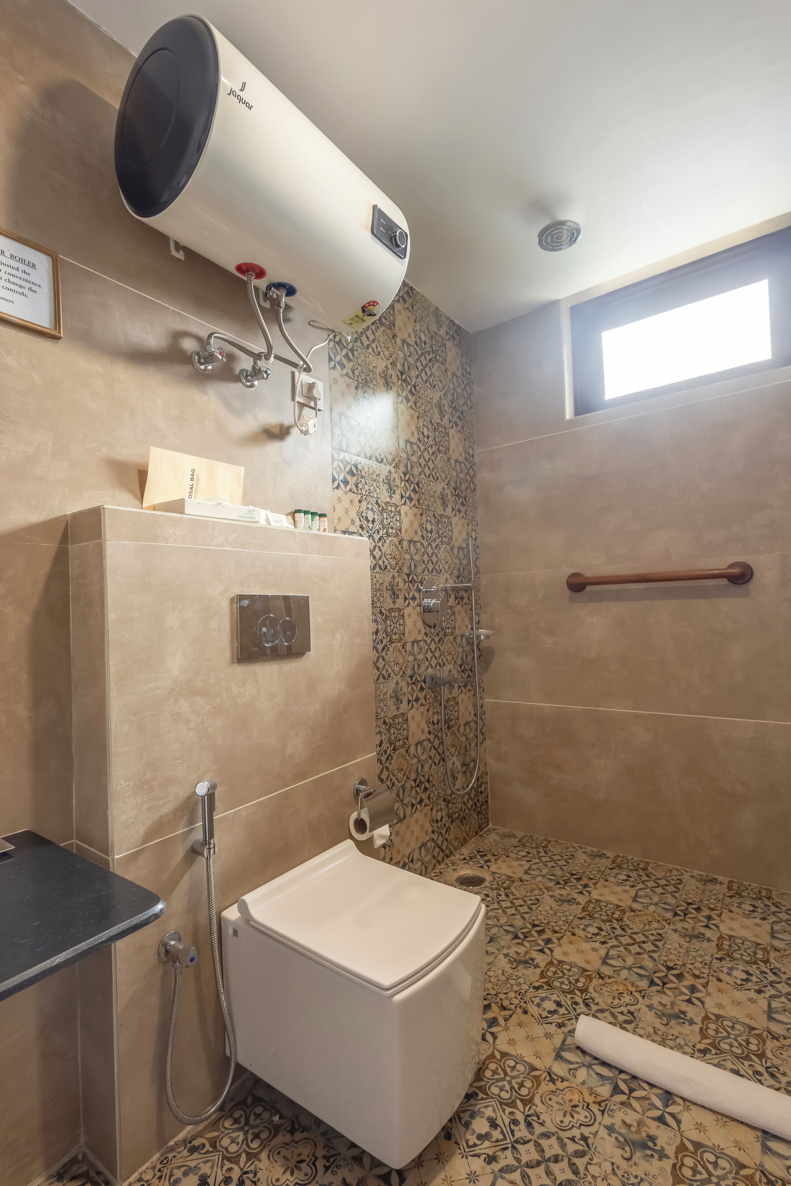 Un baño con inodoro, ducha y barra para toallas.