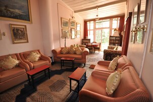 A cozy living room with striped sofas, a coffee table, and a bookshelf.