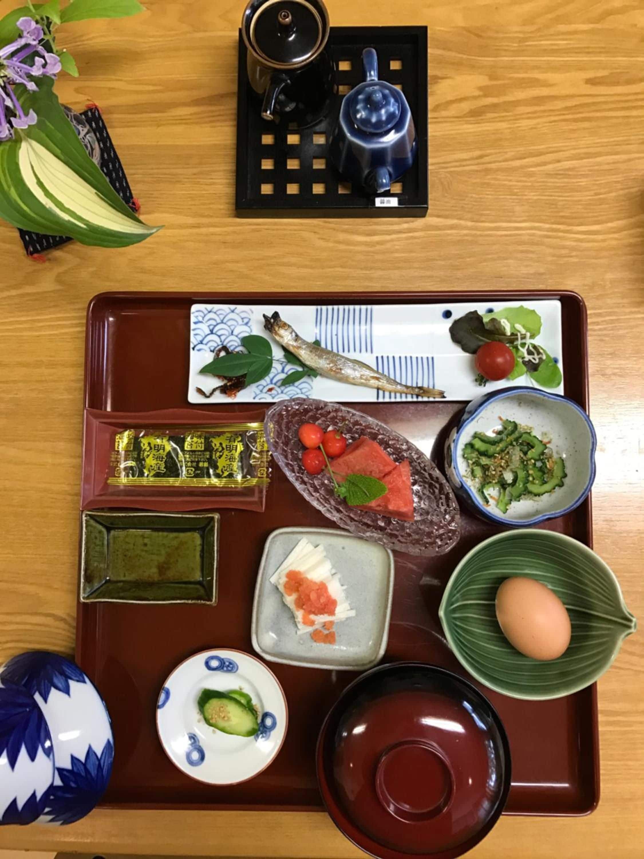 Een traditionele Japanse maaltijdopstelling met diverse gerechten en een theepot op een dienblad.