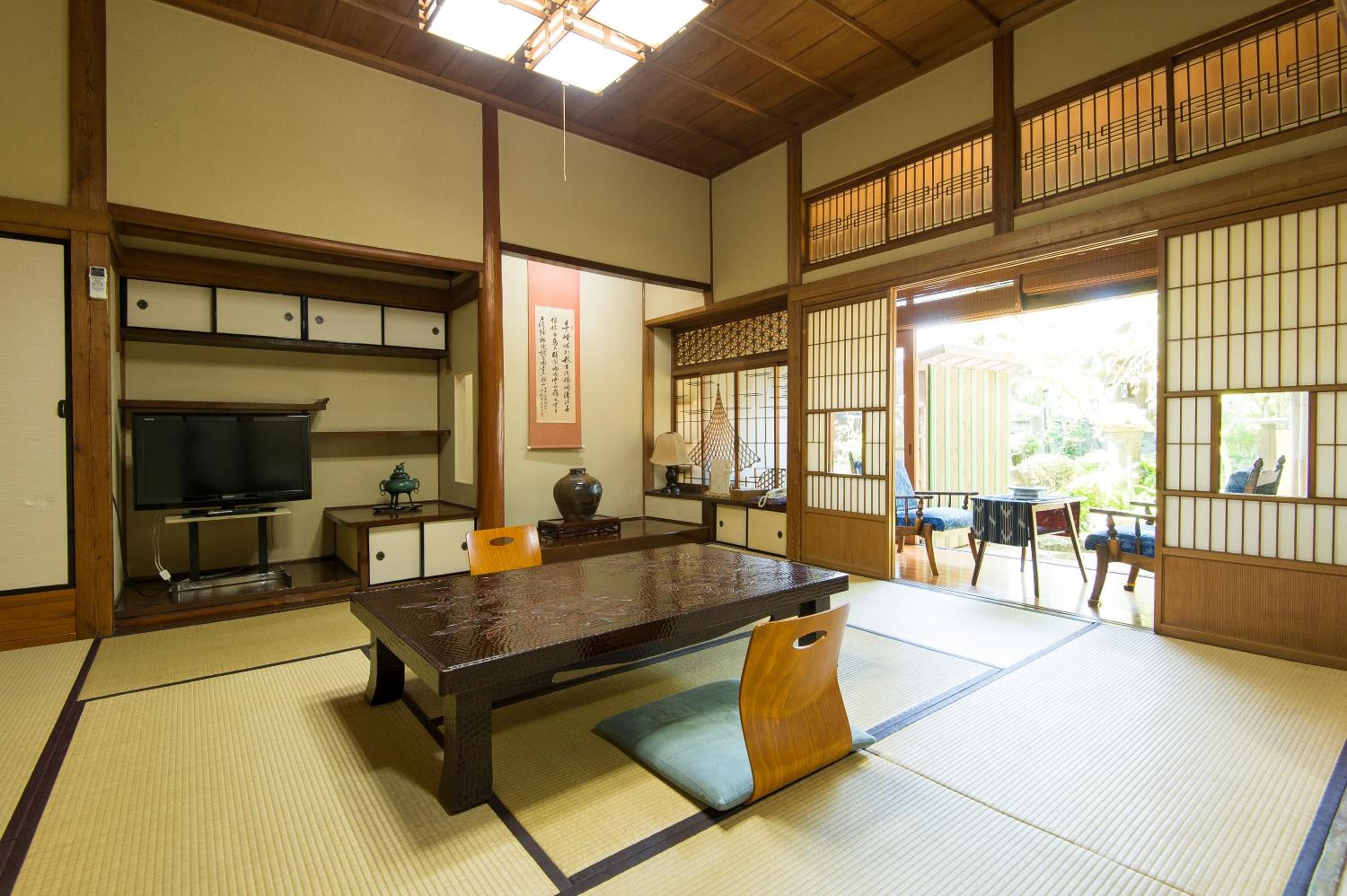 A traditional Japanese room with tatami flooring, a low table, and sliding doors.