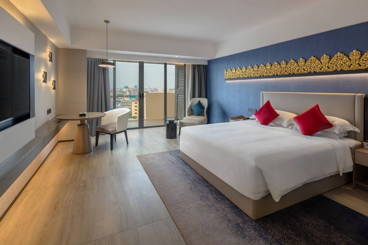 Ein modernes Hotelzimmer mit einem großen Bett, einem Schreibtisch und einem Stuhl.