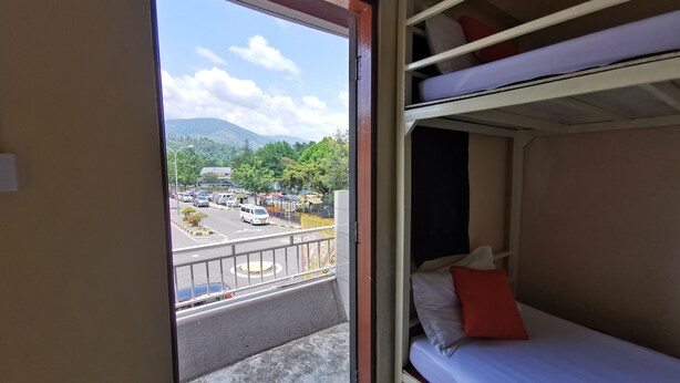 A bunk bed room with a view of a parking lot and mountains. - Lodge88 2 (Ranau)