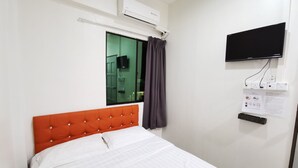A hotel room with a single bed, an orange headboard, a window with curtains, a mounted flat-screen TV, and an air conditioning unit. - Lodge88 2 (Ranau)
