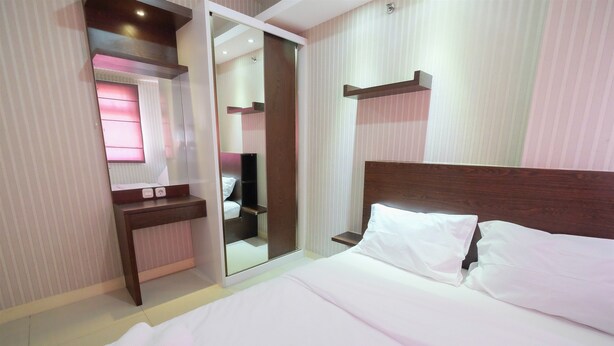 Ein Hotelzimmer mit einem Bett, einem Nachttisch, einem Spiegel und einem Kleiderschrank.