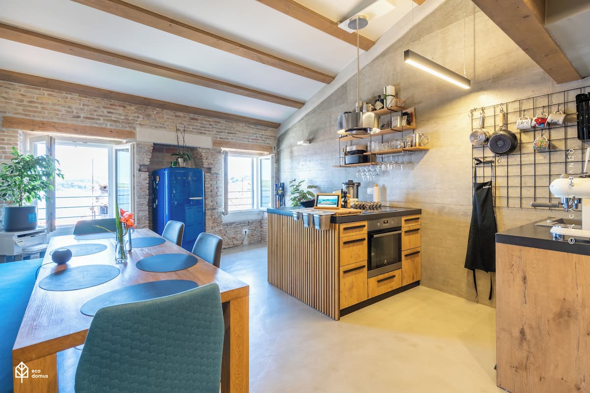 A modern kitchen with wooden cabinets, a central island, and a hanging pot rack.