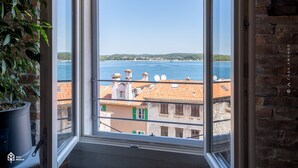 A room with a large window overlooking a body of water and buildings. - Casa Amando Eco Boutique House (Rovinj)