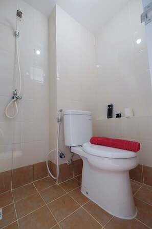 Ein Badezimmer mit Toilette, Dusche und Handtuchhalter.