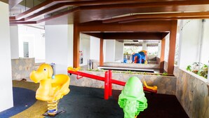 A children's play area with a seesaw and two spring-mounted toys. - Best Deal Studio Bassura Apartment (Jakarta)
