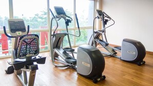 A gym with cardio machines, a stationary bike, and a rowing machine.