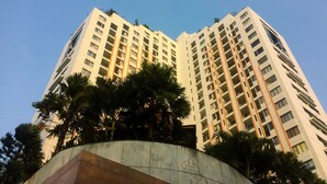 A high-rise building with multiple floors, surrounded by palm trees.
