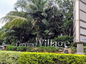 A sign for 'Cervino Village' with a stone wall and lush greenery in the background. - 2BR with Sofa Bed Cervino Tebet Apartment (Jakarta)