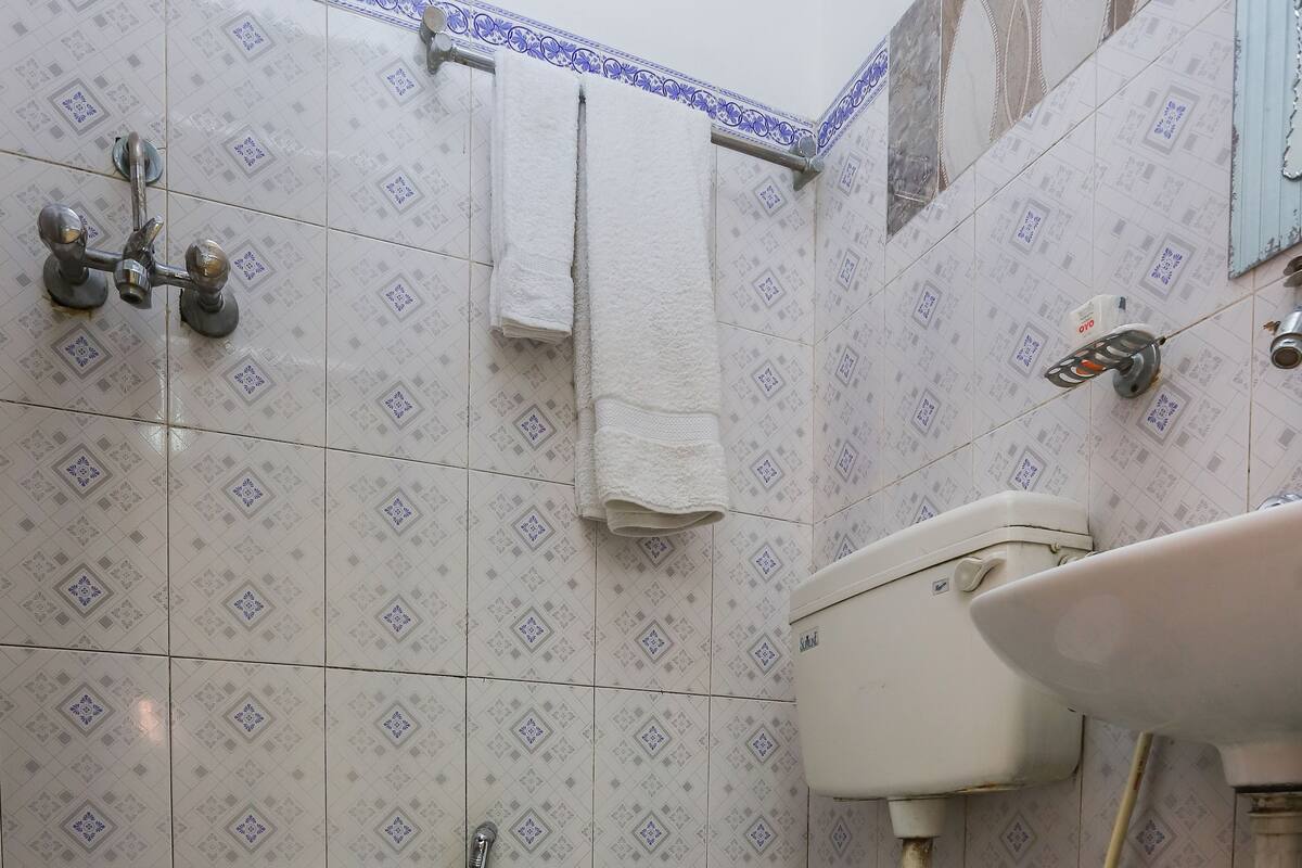 Casa de banho com sanita, lavatório e chuveiro.