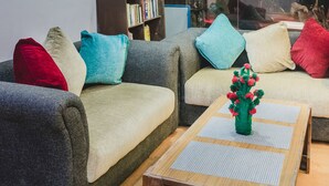 A modern living room with a sofa set, a coffee table, and a bookshelf. - Hotel Four Eyes (Kathmandu)