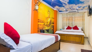 A hotel room with two beds, a mural of Buddha, a clock, and an air conditioning unit. - Hotel Four Eyes (Kathmandu)