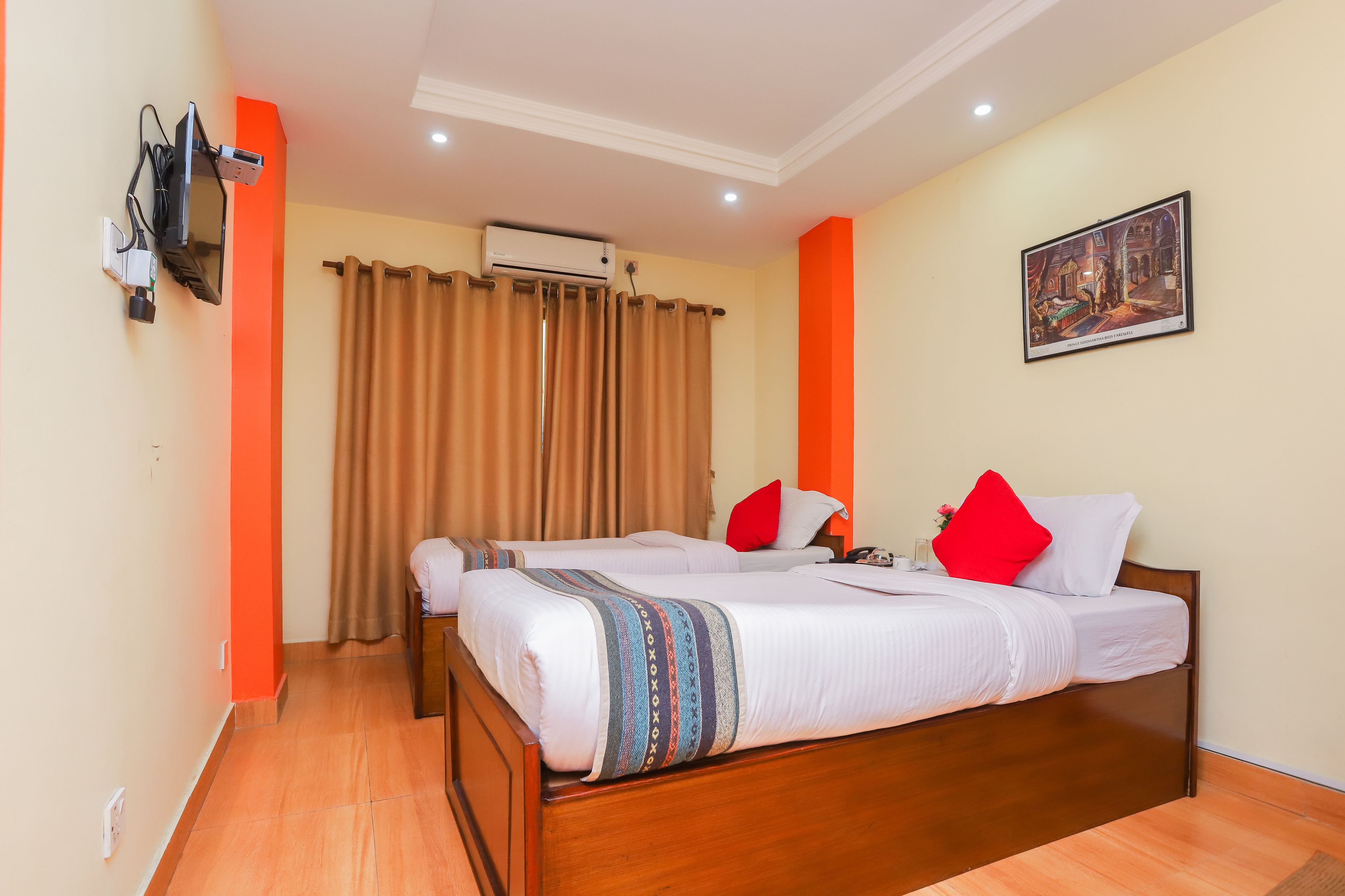A hotel room with two beds, a painting on the wall, and an air conditioning unit.