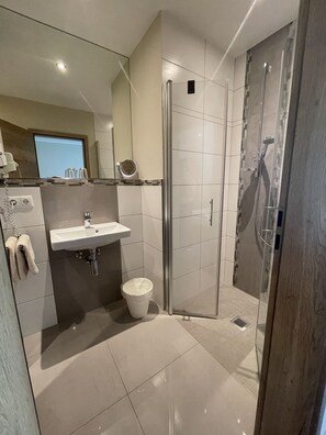 Ein modernes Badezimmer mit Glasdusche, Waschbecken und Toilette.