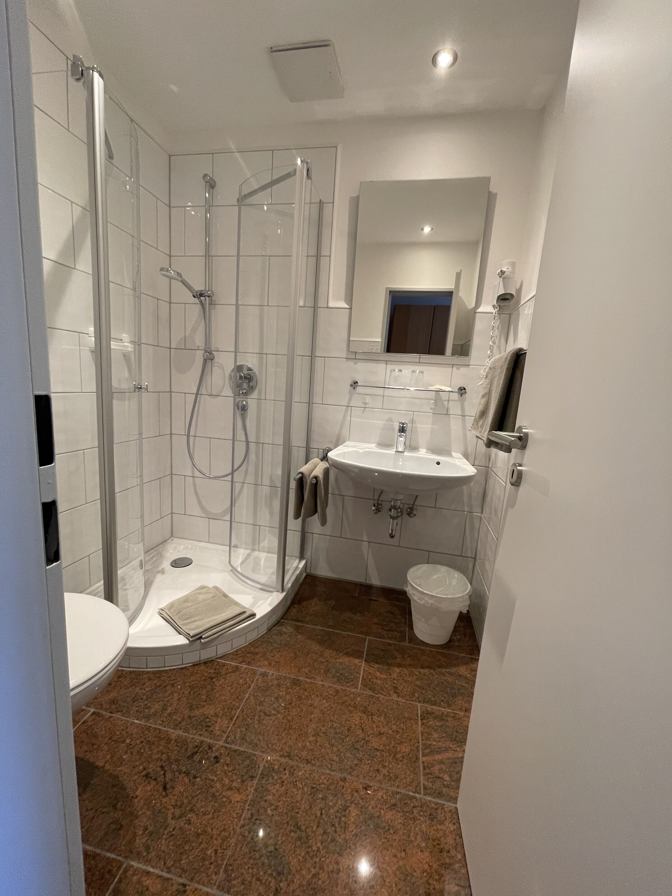 Ein modernes Badezimmer mit einer Duschkabine, einem Waschbecken und einer Toilette.