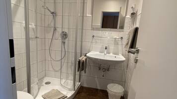 Ein modernes Badezimmer mit einer Duschkabine, einem Waschbecken und einer Toilette.