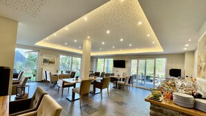 Un comedor espacioso con techos altos, ventanas grandes y un sistema de buffet.