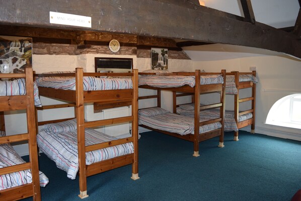 A room with bunk beds, a clock on the wall, and a sign that says "MIND YOUR HEAD". - River Wye Bunkhouse (Hereford)