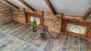 A rustic room with exposed wooden beams, a brick wall, and a tiled floor. - Windmill Studios (Bucharest)