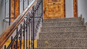 A staircase with granite steps and a wooden door at the top. - Windmill Studios (Bucharest)