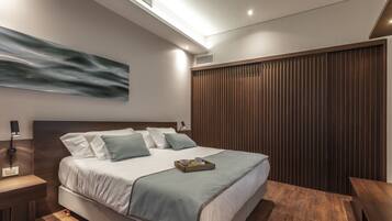 Un dormitorio moderno con una cama grande, cabecera de madera y suelo de madera.