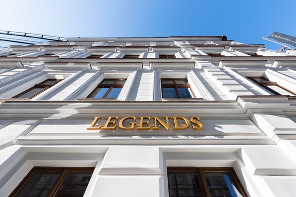 Fachada de edificio con la palabra 'LEGENDS' destacada en letras doradas.